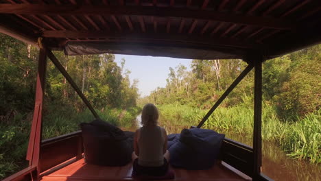 Woman-sitting-on-boat-in-jungle