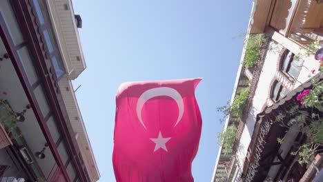 Cámara-Lenta-De-Una-Gran-Bandera-Turca-Colgando-Y-Volando-Sobre-La-Calle-En-Estambul,-Turquía
