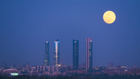 Moon-rising-over-the-Cuatro-Torres-in-Madrid,-Spain