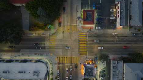 Busy-Intersection-Seen-from-Above,-Aerial-Drone-Shot-of-Cars-Moving-Through-Intersection-in-Early-Evening-Hours