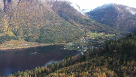Ferry-Kinsarvik-approaching-Kinsarvik-village-in-beautiful-autumn-landscape-with-colorful-trees-and-snow-in-foggy-mountain-peaks---Hardanger-Ullensvang-Norway-static-aerial