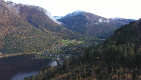 Kinsarvik-village-revealed-behind-autumn-hillside-in-stunning-landscape-surroundings-and-majestic-mountains---Hardanger-Ullensvang-Norway
