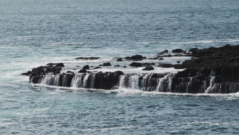 Water-draining-from-ocean-waves-on-rocky-shoreline