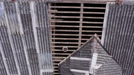 Corrugated-asbestos-roof-replacement-materials,-overhead-zoom-into-exposed-frame