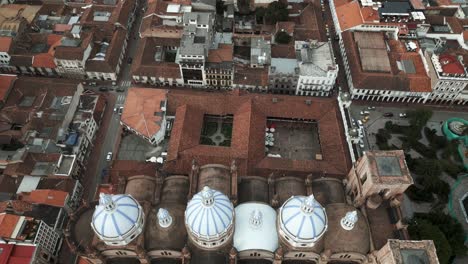 Zoom-Out-Aerial-Fly-Above-Cuenca-Ecuador-New-Cathedral-Domes-City-Buildings-Road-Traffic,-Traditional-Architecture,-Colonial-Feeling,-Historic-Center,-Travel-and-Tourism-in-Latin-America