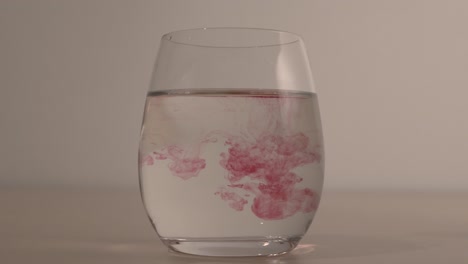 Rote-Tropfen-Tanzen-In-Einem-Glas-Wasser