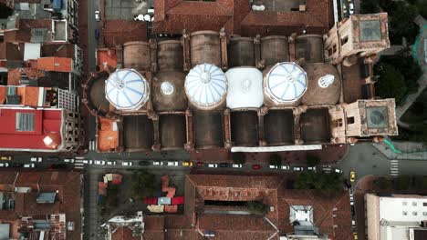 Aerial-Drone-Above-New-Cathedral-of-Cuenca,-Ecuador,-Historic-City-Center-Roofs-and-Three-White-Domes-of-the-Church,-Traditional-Colonial-Latin-American-Architecture