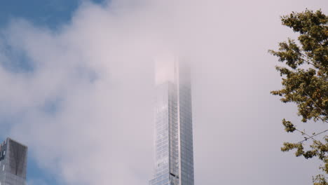 Torre-De-Rascacielos-Sobre-Las-Nubes,-Manhattan-De-La-Ciudad-De-Nueva-York,-Central-Park-Acristalado-Arquitectura-Moderna-De-Gran-Altura-Y-Edificio-Alto-Residencial-Cubierto-Por-Nubes,-Vista-De-ángulo-Bajo