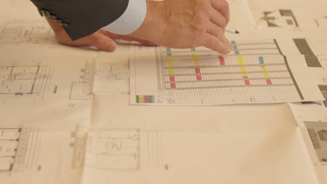 Man-pointing-at-floor-plan-in-office