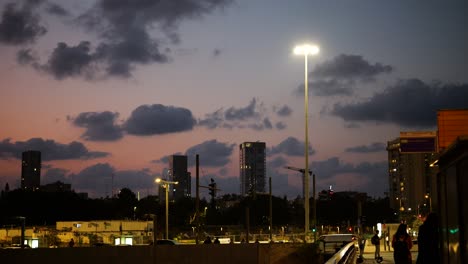 Car-traffic-and-pedestrians-on-the-streets-of-Tel-Aviv-in-the-evening,-establishing-shot