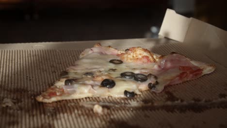 Rebanada-De-Pizza-Sentada-En-Una-Caja-De-Cartón,-De-Cerca,-A-Cámara-Lenta