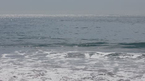 Weite-Sicht-Auf-Surfer,-Die-über-Klarem-Aquawasser-Und-Kleinen-Wellen-Paddeln