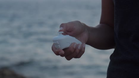 Girl-by-the-sea-with-VR-motion-controllers-in-her-hand,-close-up,-slow-motion