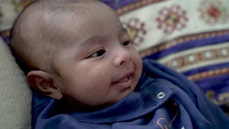 Entzückender-2-Monate-Alter-Junge-Aus-Bangladesch,-Der-Lächelt-Und-Lacht,-Während-Er-Auf-Dem-Kissen-Ruht
