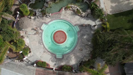 Top-Down-Aerial-View-of-Circular-Hot-Springs-Pool-in-Luxury-Resort,-High-Ange-Rising-Drone-Shot