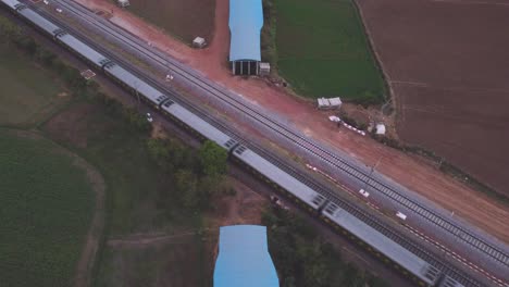 Train-passing-above-a-Railway-Underpass-at-a-village-of-Gwalior-Aerial-top-down-Drone-shot