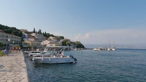 Panning-shot-of-boats-swaying-in-the-old-port-of-Kassiopi,-Corfu,-Greece