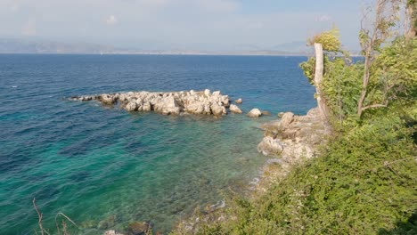 View-of-landscape-and-rocky-coast-of-Kassiopi-on-Corfu-island,-waves-on-turquoise-sea