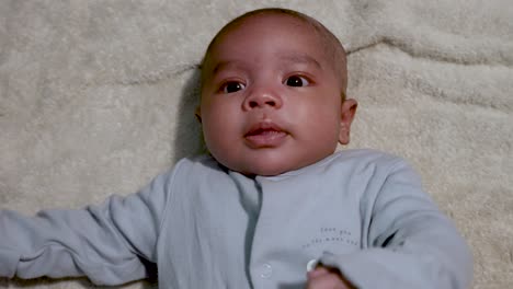 Cute-2-Month-Old-Baby-Boy-Wriggling-On-Blanket-Looking-Up-Being-Animated