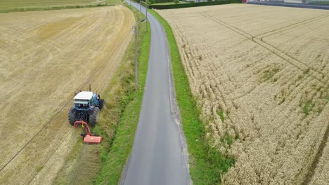 Drone-shot-of-a-tractor-mowing-the-grass-verge