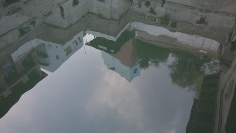 Artful-Shot-of-Water-Reflecting-the-Buildings-above-in-the-Toorji-Ka-Jhalra-Stepwell,-Jodhpur,-Rajasthan