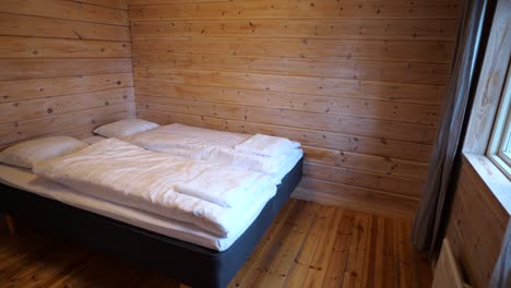 Bed-in-small-wooden-room-in-northern-Sweden,-Scandinavian-lodging