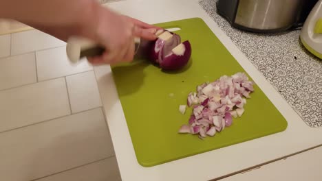Caucasian-woman-cooking-and-cutting-up-purple-onion
