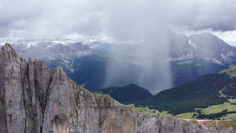 Rain-storm-in-mountain-valley,-view-from-Seceda-ridgeline-in-Dolomites