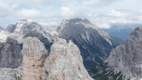 Epic-aerial-shot-of-alpinist-on-top-of-Torre-di-Toblin,-Dolomites,-Italy