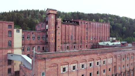 Drone-approaching-a-giant-old-brick-factory-in-the-evening-sun-a-lost-socialist-place-in-the-middle-of-Germany