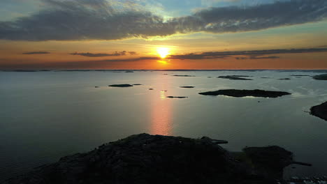 Aerial-vivid-sunset-with-intense-and-cinematic-colours-at-a-rocky-coastline-with-a-marina-and-islands-in-the-archipelago