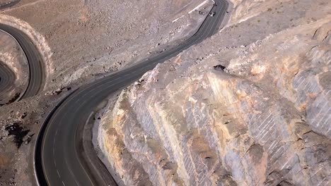 The-winding-road-by-the-mountainside-of-Jebel-Jais-in-Ras-Al-Khaimah,-UAE,-perfect-for-a-roadtrip---Aerial-shot