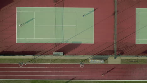 Drohnenaufnahme-über-Tennisplätzen-Mit-Menschen,-Die-Tennis-Spielen