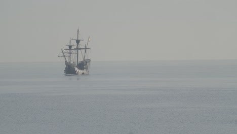 Ferdinand-Magellan-Nao-Victoria-Carrack-Bootsreplik-Mit-Spanischer-Flagge-Segelt-Im-Mittelmeer-Bei-Sonnenaufgang-In-Ruhigem-Meer,-Das-Den-Rahmen-In-Zeitlupe-60fps-Verlässt