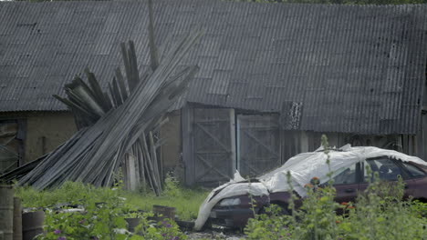 Abandoned-car-in-front-of-a-collapsed-wooden-barn