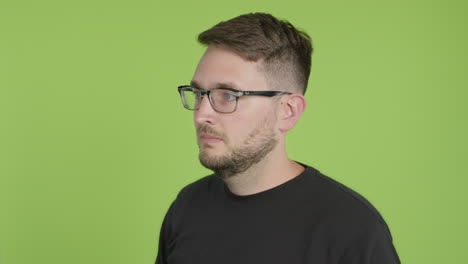 Man-in-Glasses-Removes-Protective-KN95-Face-Mask-While-Looking-Left-of-Camera-on-Green-Screen-Chroma-Key