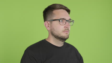 Man-in-Glasses-Removes-Protective-KN95-Face-Mask-While-Looking-Right-of-Camera-on-Green-Screen-Chroma-Key