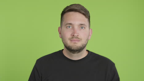 Man-Removes-Protective-KN95-Face-Mask-While-Looking-Into-Camera-on-Green-Screen-Chroma-Key