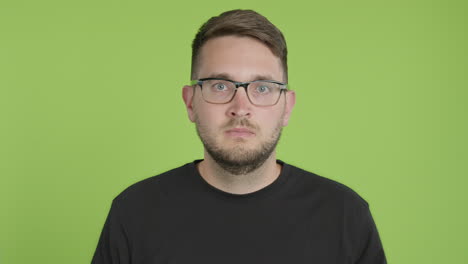 Man-in-Glasses-Removes-Protective-KN95-Face-Mask-While-Looking-Into-Camera-on-Green-Screen-Chroma-Key