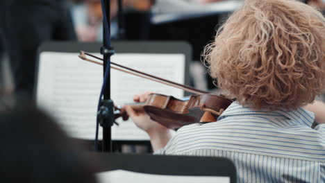 A-violinist-in-the-back-plays-classical-music-in-an-orchestra