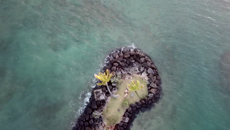 Aerial-footage-of-little-island-in-Kahala,-Hawaii-with-loving-couple-sunbathing