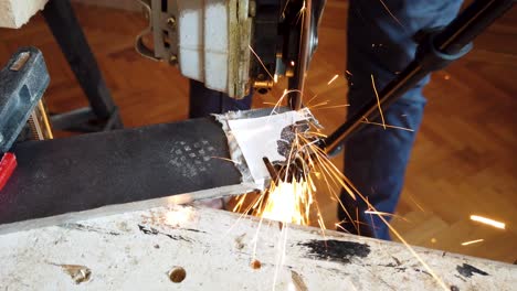 Close-up-cutting-steal-with-angle-grinder-in-small-working-shop