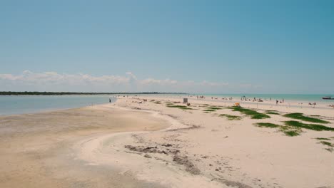 Flying-Low-Over-People-Enjoying-Summer-Time-On-Long-Sandy-Beach,-HOLBOX