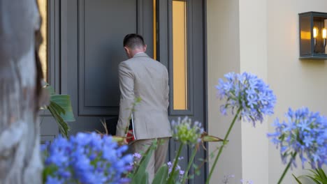 Slow-motion-shot-of-male-businessman-entering-luxury-villa-door---panning-shot