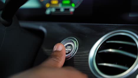 Man's-thumb-pressing-the-button-start-stop-engine-in-a-car