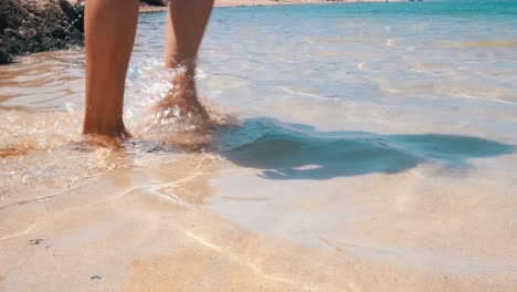 Woman-walking-through-shallow-water,-feet