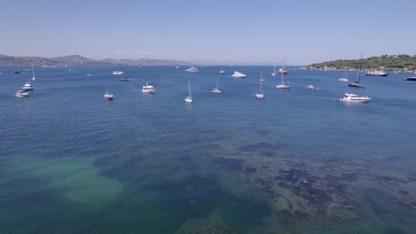 Establishing-drone-shot-of-multiple-yachts-anchored-in-a-stunning-French-bay