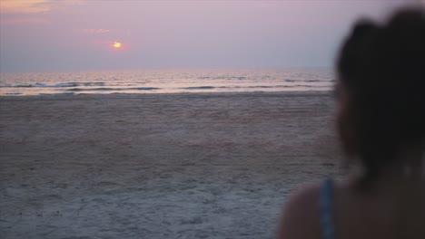 Junge-Frau,-Die-Den-Sonnenuntergang-über-Dem-Ruhigen-Ozean-Beobachtet