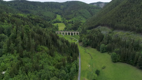 Toma-Aérea-De-Una-Calle-Y-Un-Viaducto-Entre-Montañas,-4k-Uhd,-Semmering,-Austria