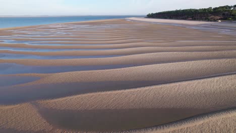 Coastal-sandy-dunes-with-water-rising-over-it,-aerial-drone-view
